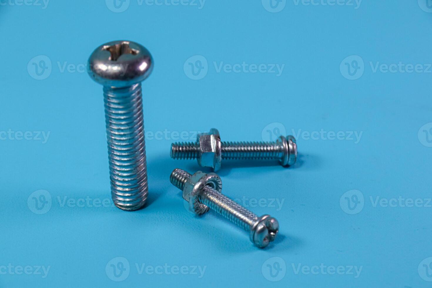 different nut and bolt on blue background photo
