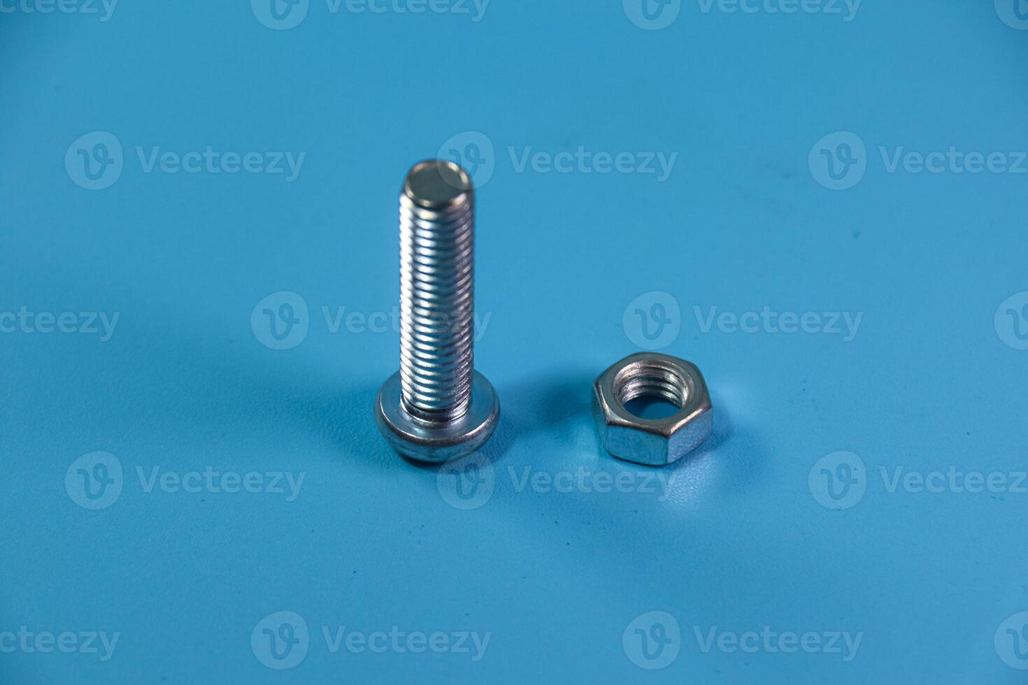 nut and bolt in close up on blue background photo