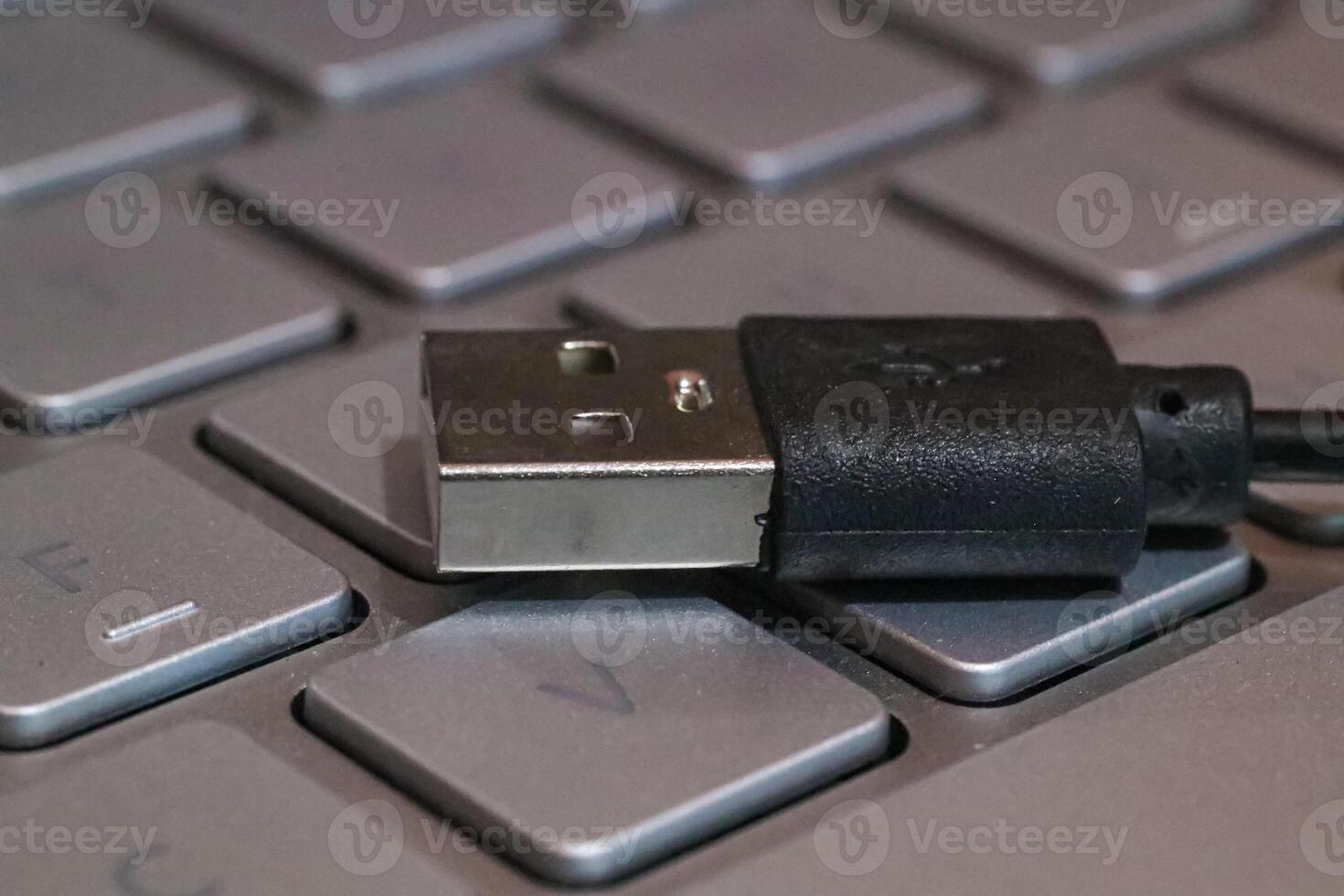 close up of usb data cable above keyboard photo