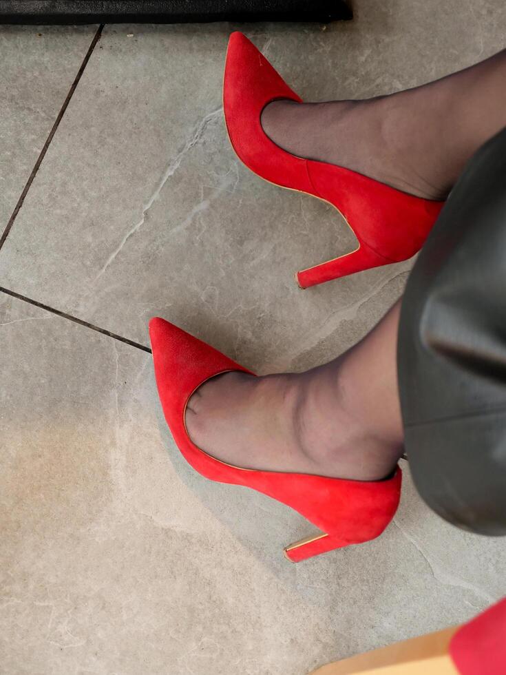 A woman wearing red heels and a black leather jacket photo
