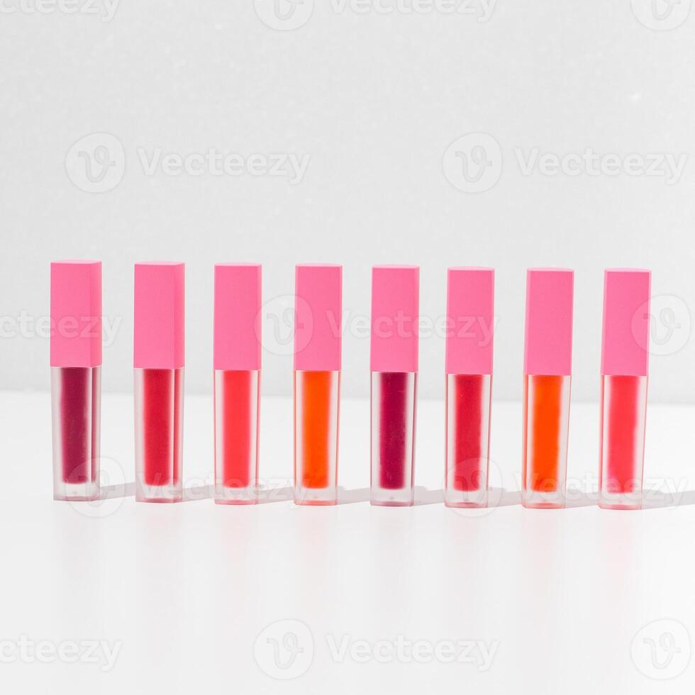 A row of lip glosses in different colors photo