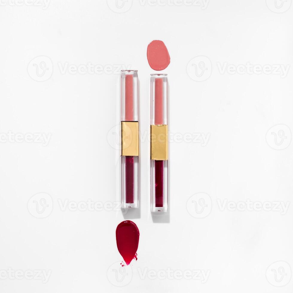 Two lipsticks are on a white surface photo