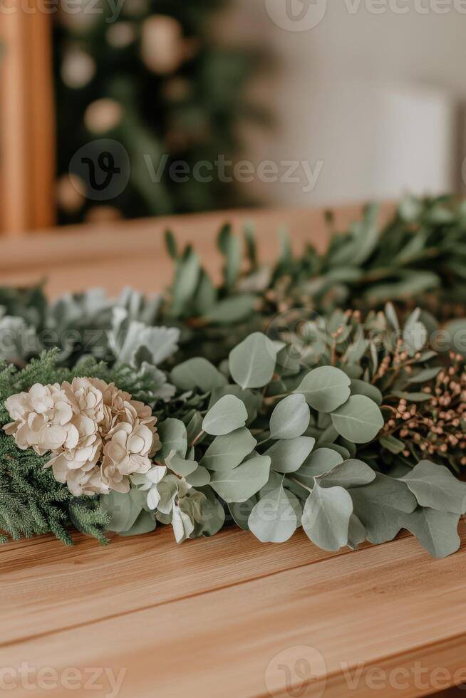Various greenery and floral elements arranged on a wooden table photo
