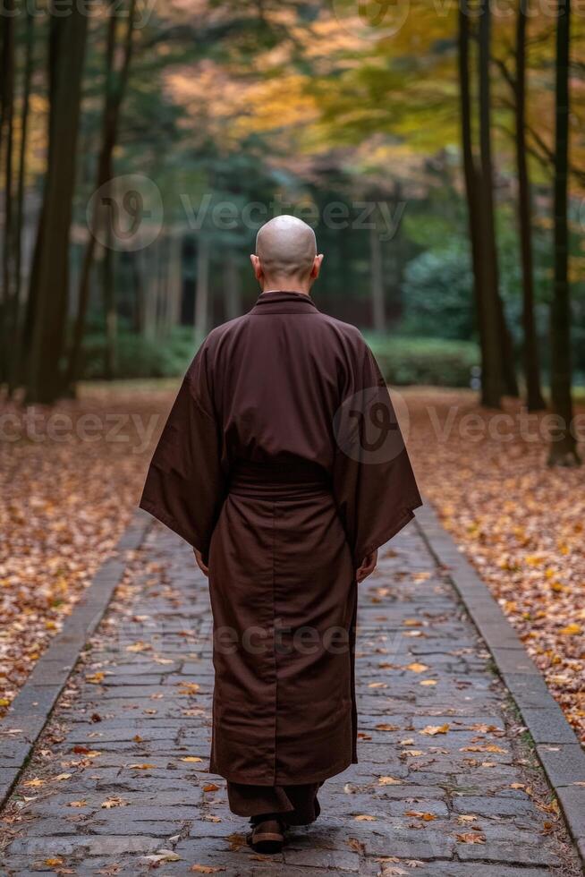 Monk walking on a stone path through autumn forest in tranquil scenery photo