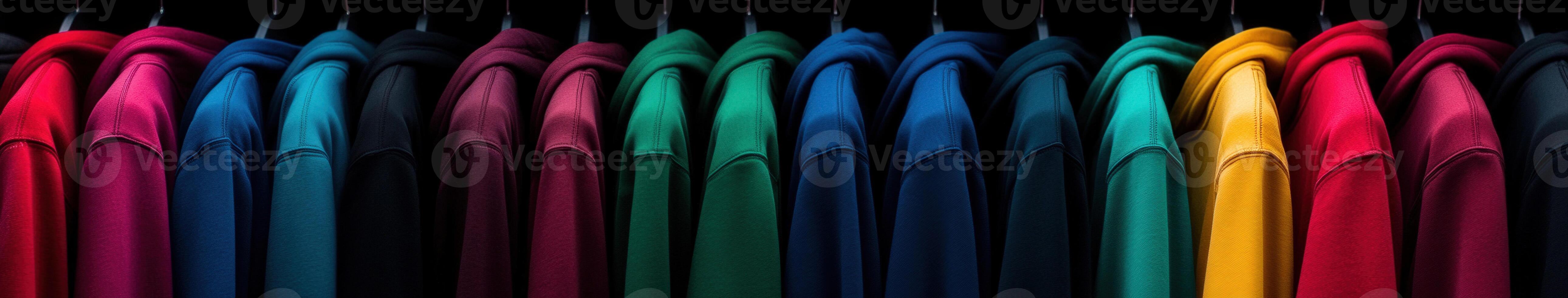A collection of colorful shirts hanging on black hangers in a store photo