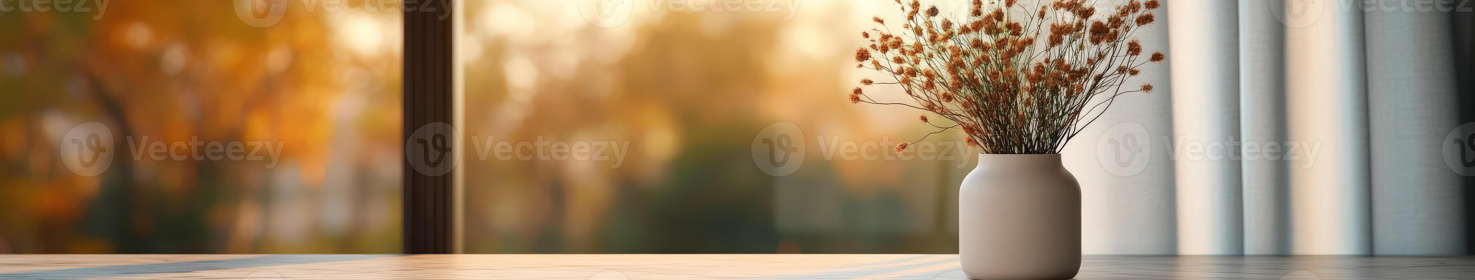 Vase with dried flowers on a table near a window during autumn light photo
