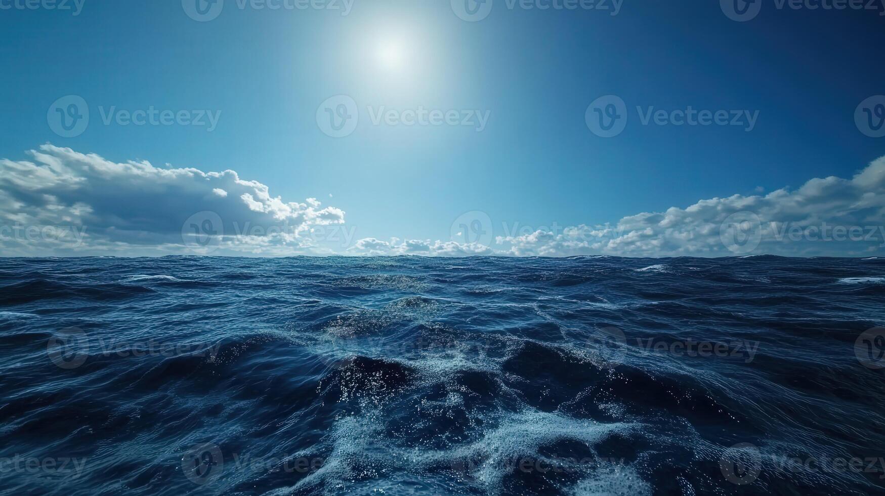 Waves under a bright sun with scattered clouds in the sky photo