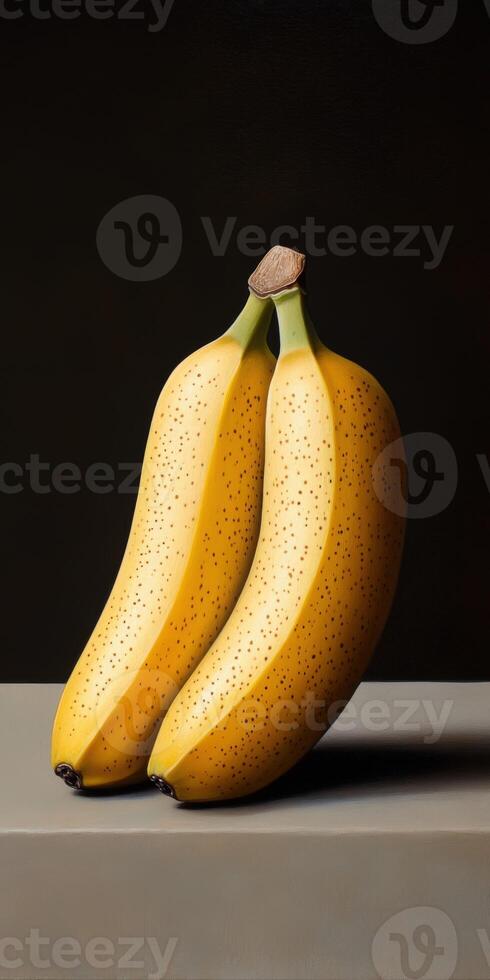 Two ripe bananas resting on a gray surface with a dark background photo
