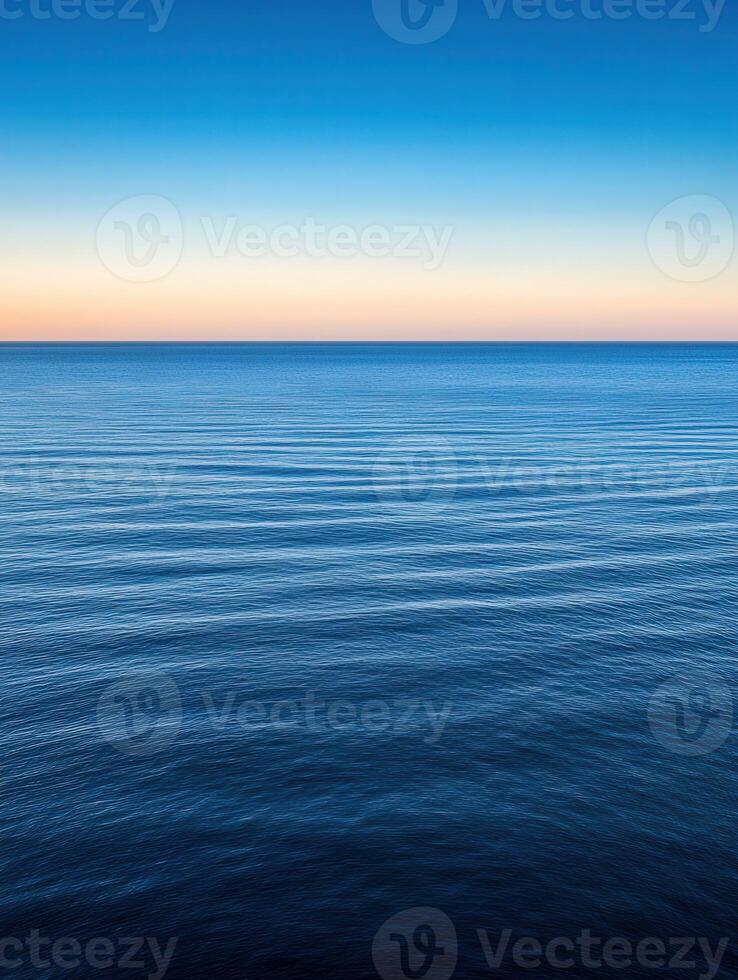 Tranquil sunset over calm ocean waters during twilight hours photo