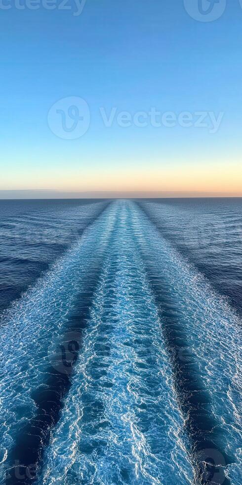 A serene view of ocean waves at sunset from a moving ship photo