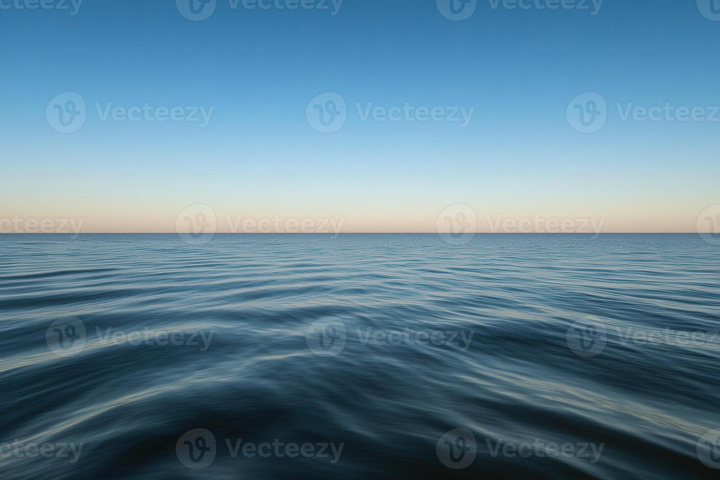 Calm ocean waves under a clear sky at sunset near a tranquil coastline photo