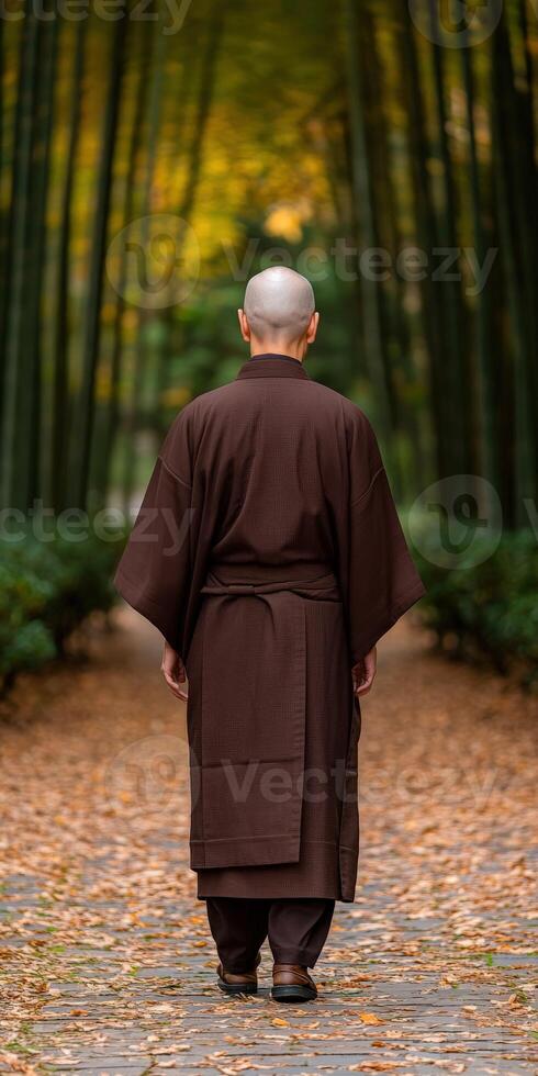 A monk walking through a serene bamboo forest during autumn photo