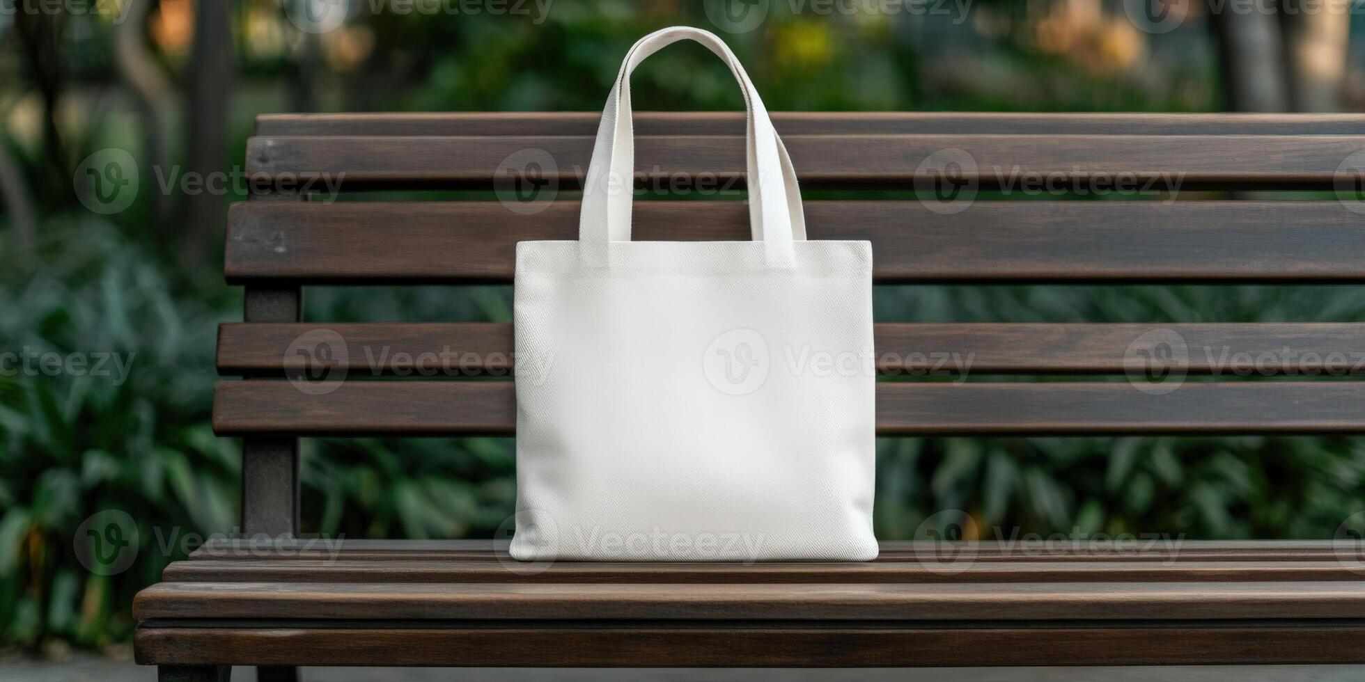 A white tote bag resting on a wooden bench in a serene park setting photo