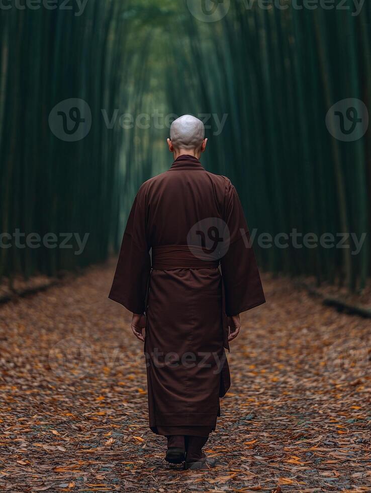 Monk walking in a serene bamboo forest during autumn evening photo