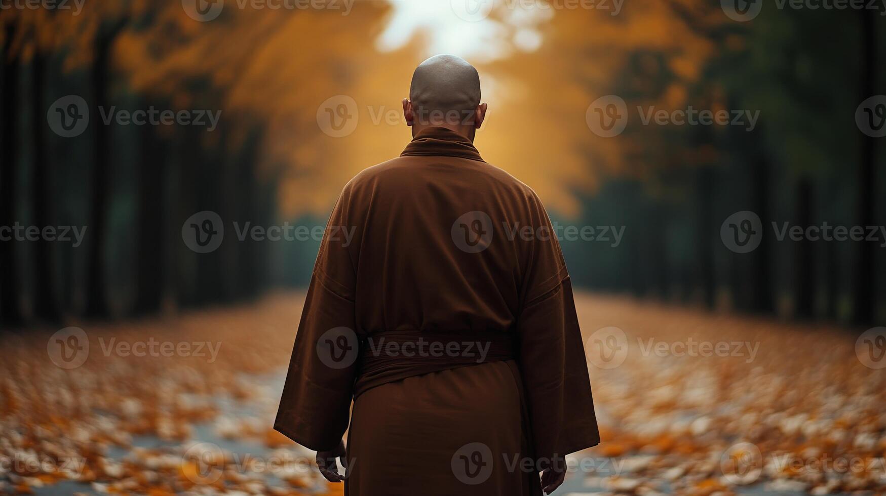 Monk walking through an autumn path surrounded by colorful foliage photo