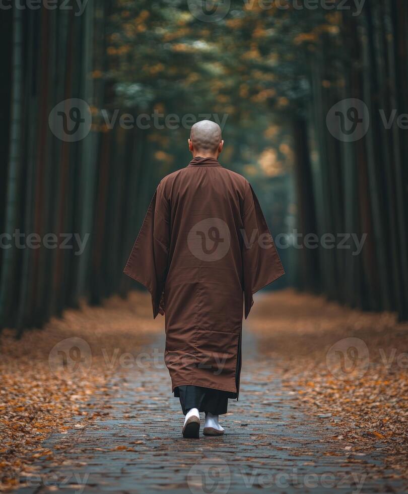 A monk walking through a tranquil bamboo forest in autumn photo