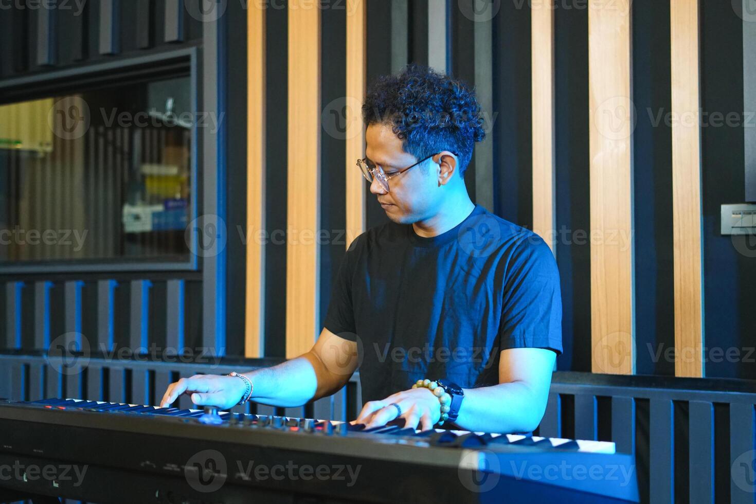 Musician playing music keyboard, Asian man playing piano and practicing in home studio photo