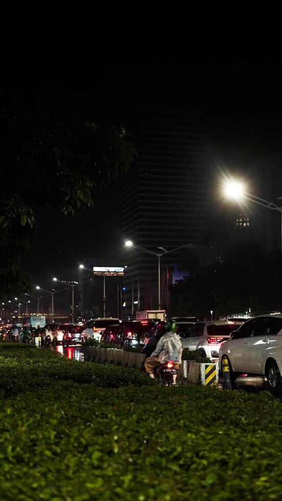 A busy city street with many people and vehicle. Concept of hustle and bustle, with people walking and cars driving in a busy urban environmen photo