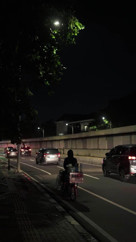 A busy city street with many people and vehicle. Concept of hustle and bustle, with people walking and cars driving in a busy urban environmen photo