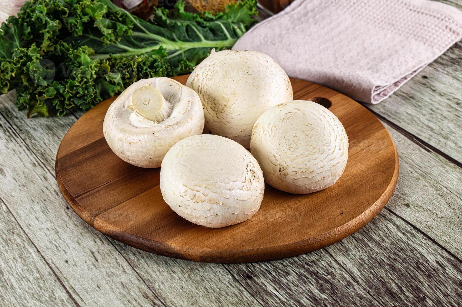 White champignon mushrooms heap over board photo