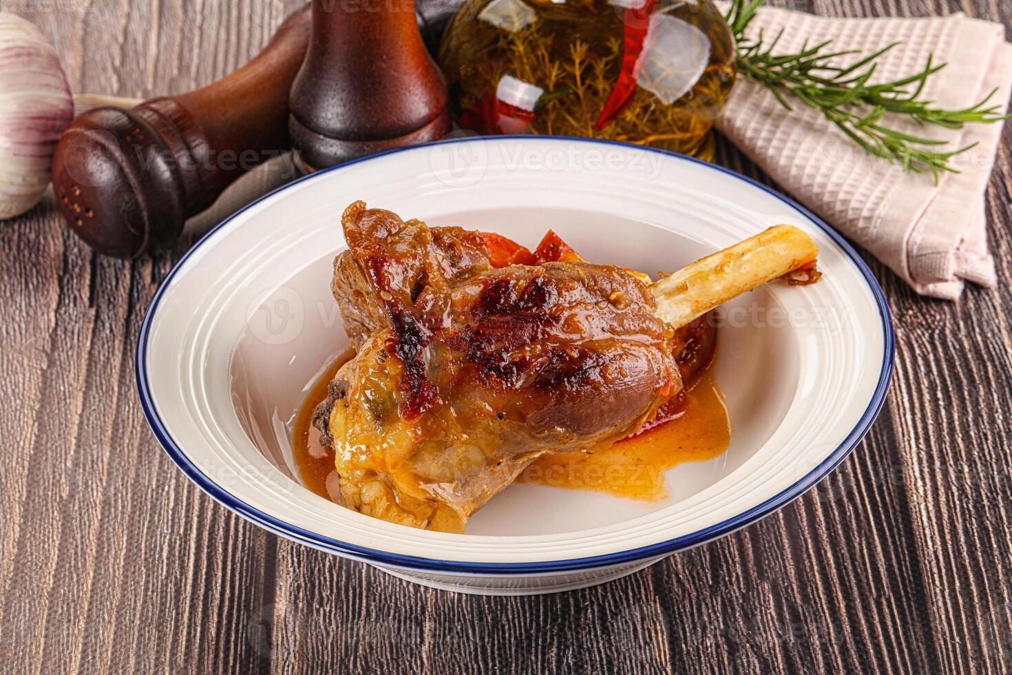 Baked lamb shank with vegetables photo