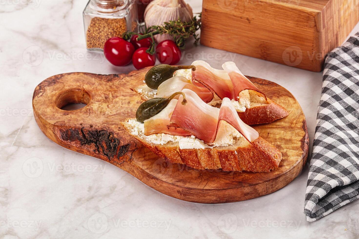 Bruschetta with jamon and caper berries photo