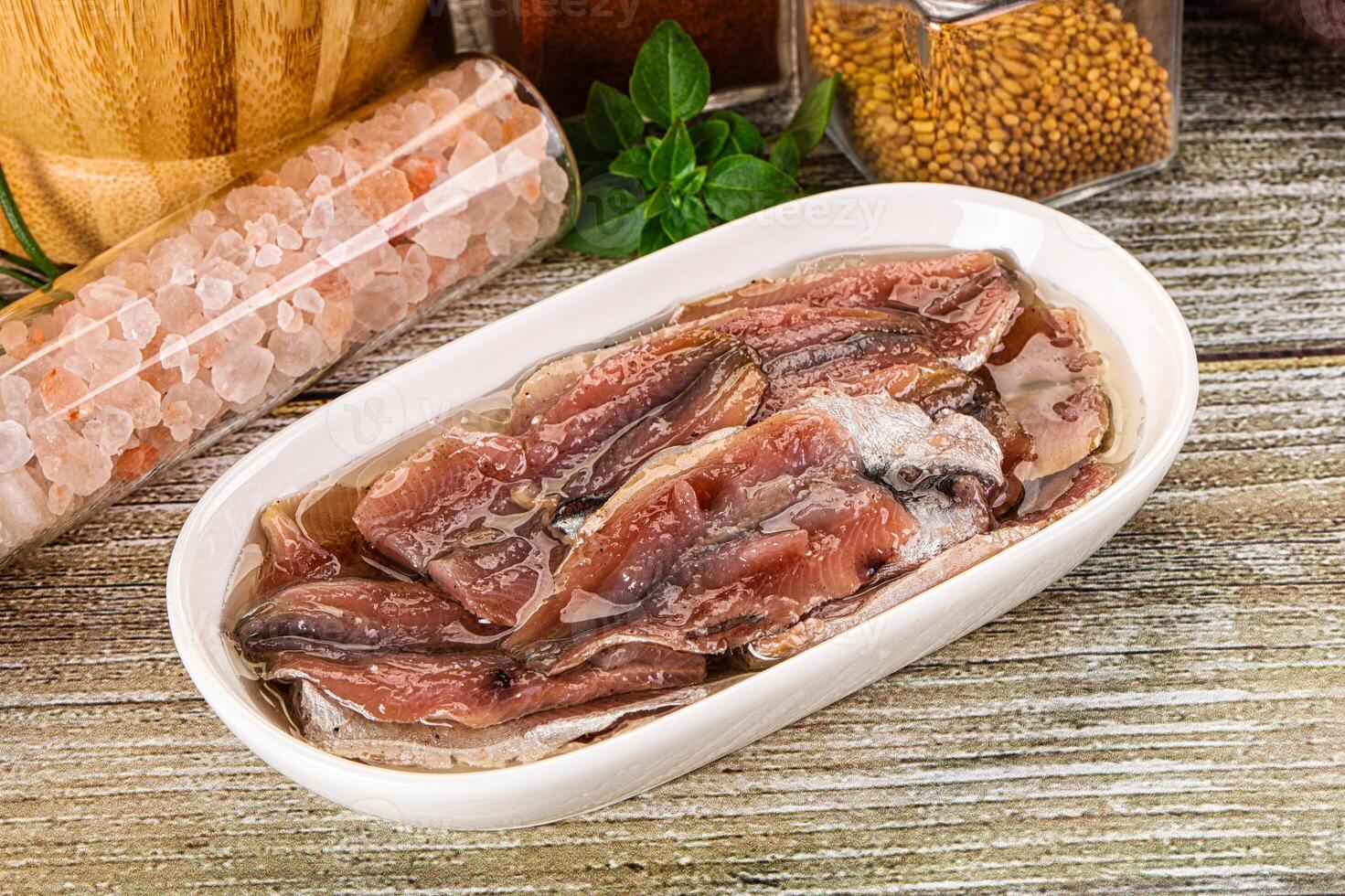 Canned anchovy with oil in the bowl photo