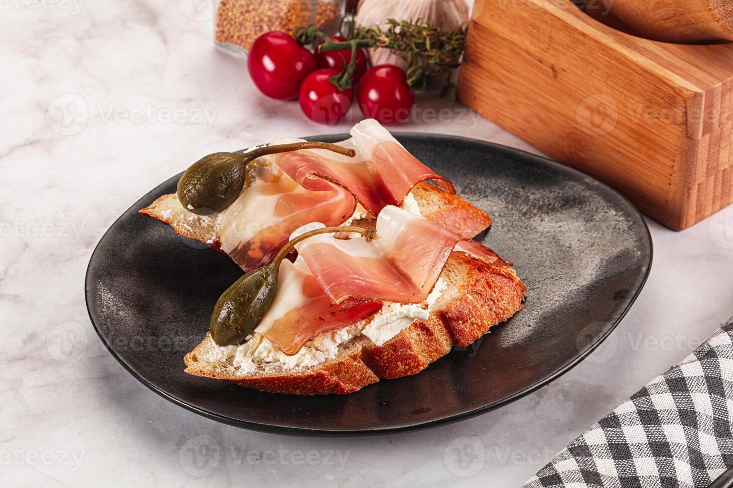 Bruschetta with jamon and caper berries photo