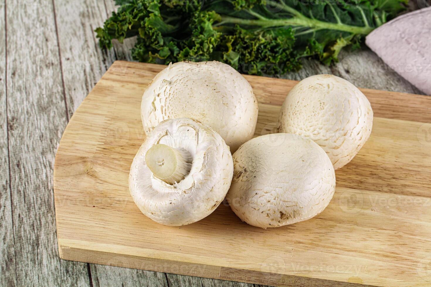White champignon mushrooms heap over board photo