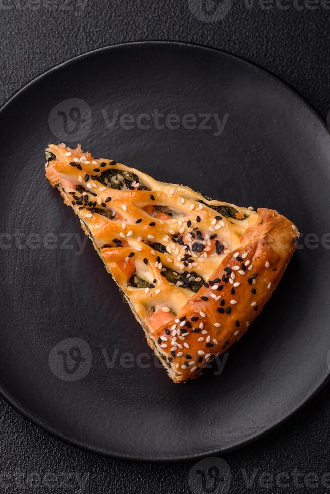 Pieces of quiche with salmon, spinach or broccoli, salt and spices photo