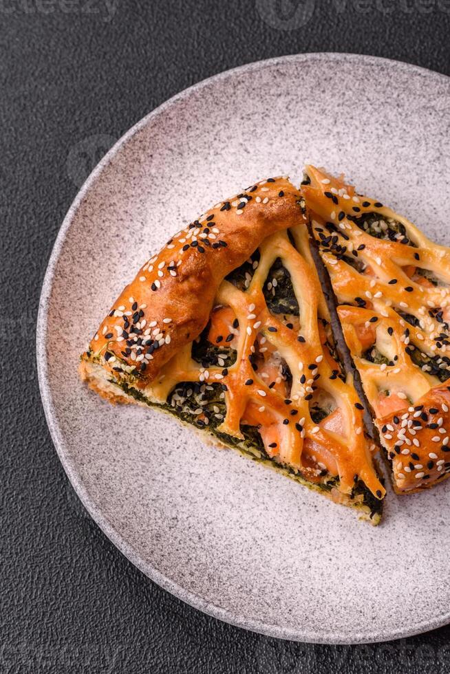 Pieces of quiche with salmon, spinach or broccoli, salt and spices photo