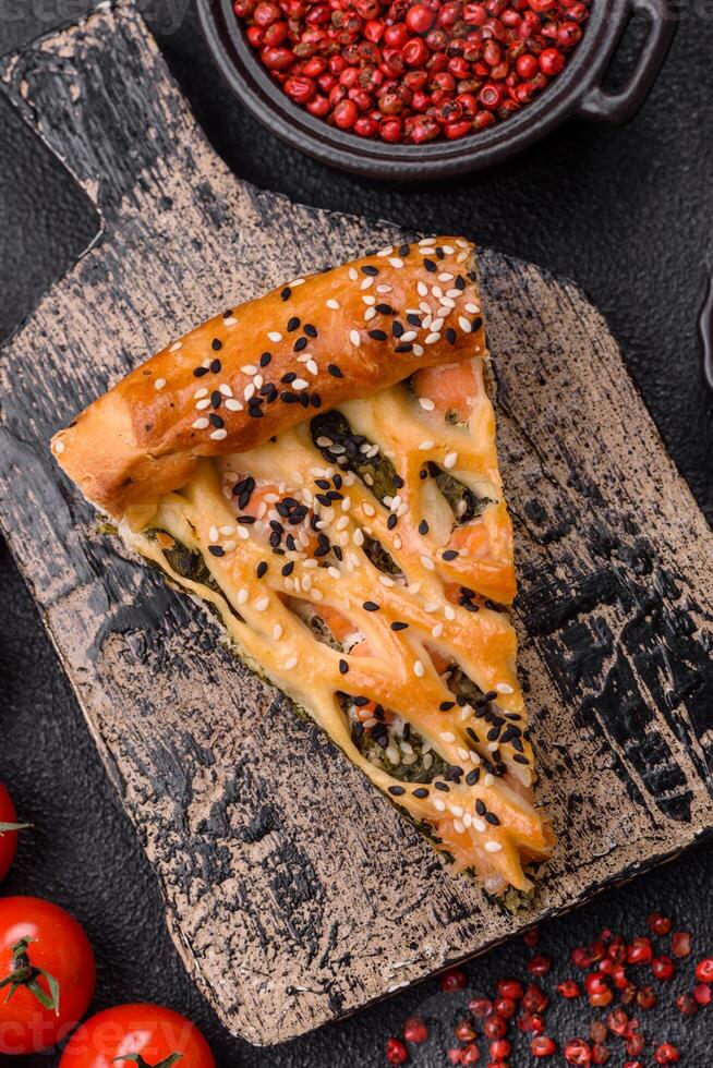 Pieces of quiche with salmon, spinach or broccoli, salt and spices photo