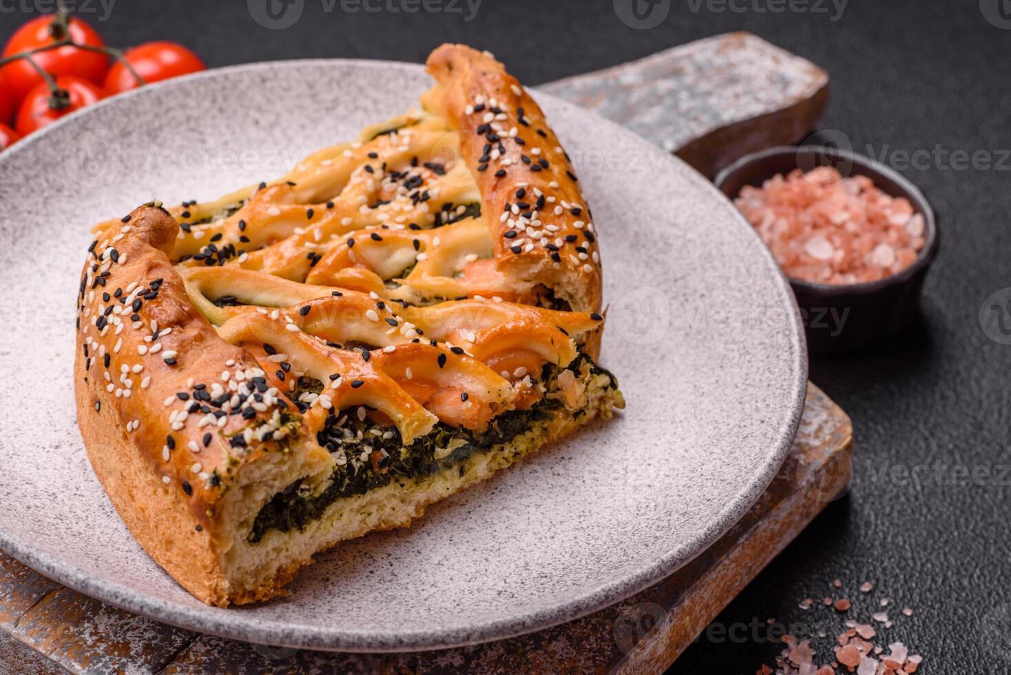 Pieces of quiche with salmon, spinach or broccoli, salt and spices photo