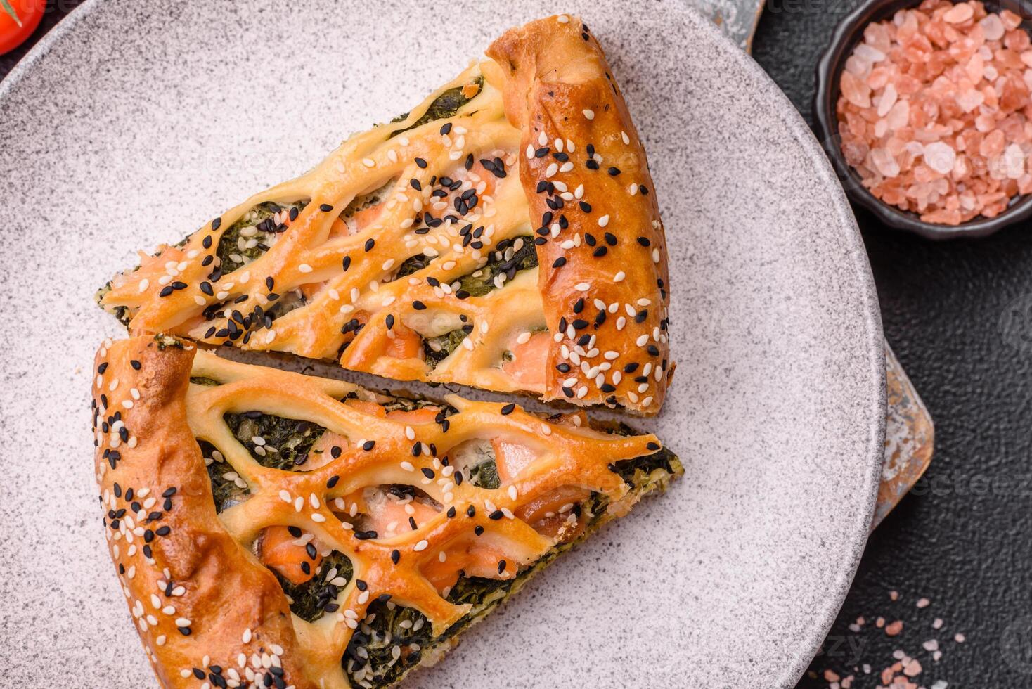 Pieces of quiche with salmon, spinach or broccoli, salt and spices photo