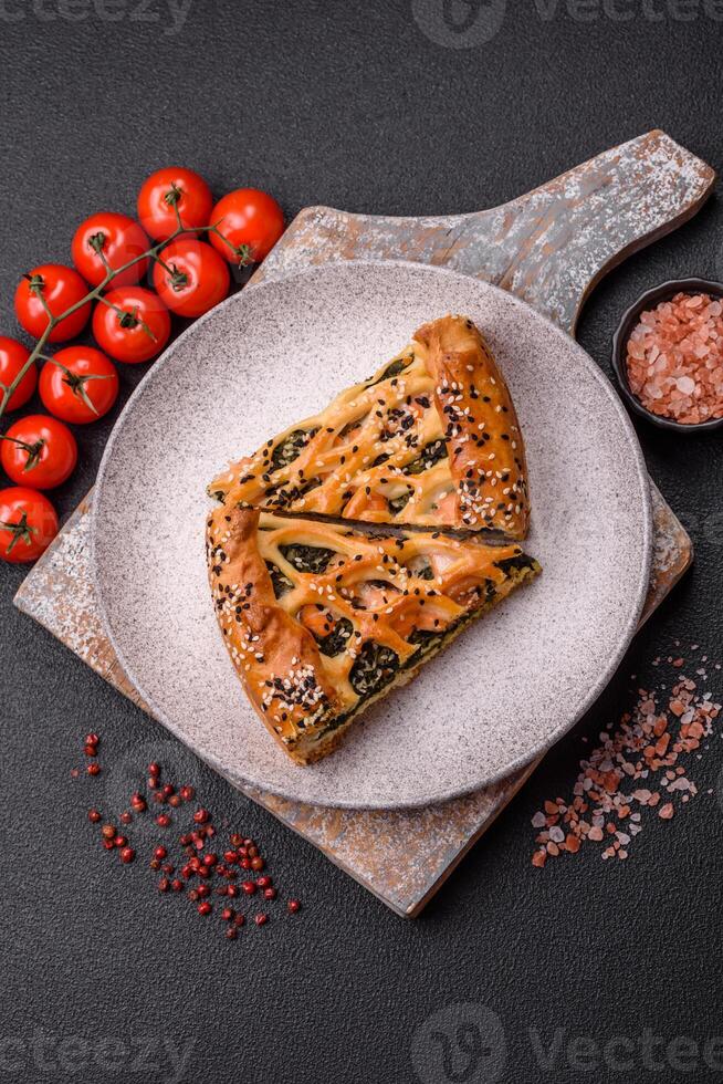 Pieces of quiche with salmon, spinach or broccoli, salt and spices photo