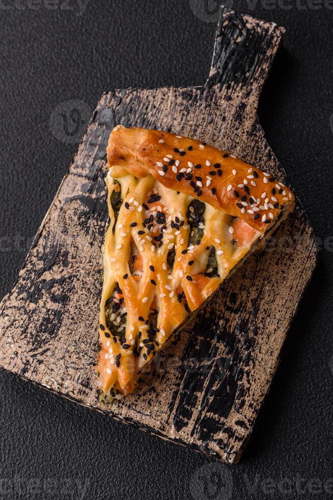 Pieces of quiche with salmon, spinach or broccoli, salt and spices photo