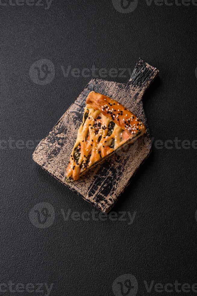 Pieces of quiche with salmon, spinach or broccoli, salt and spices photo
