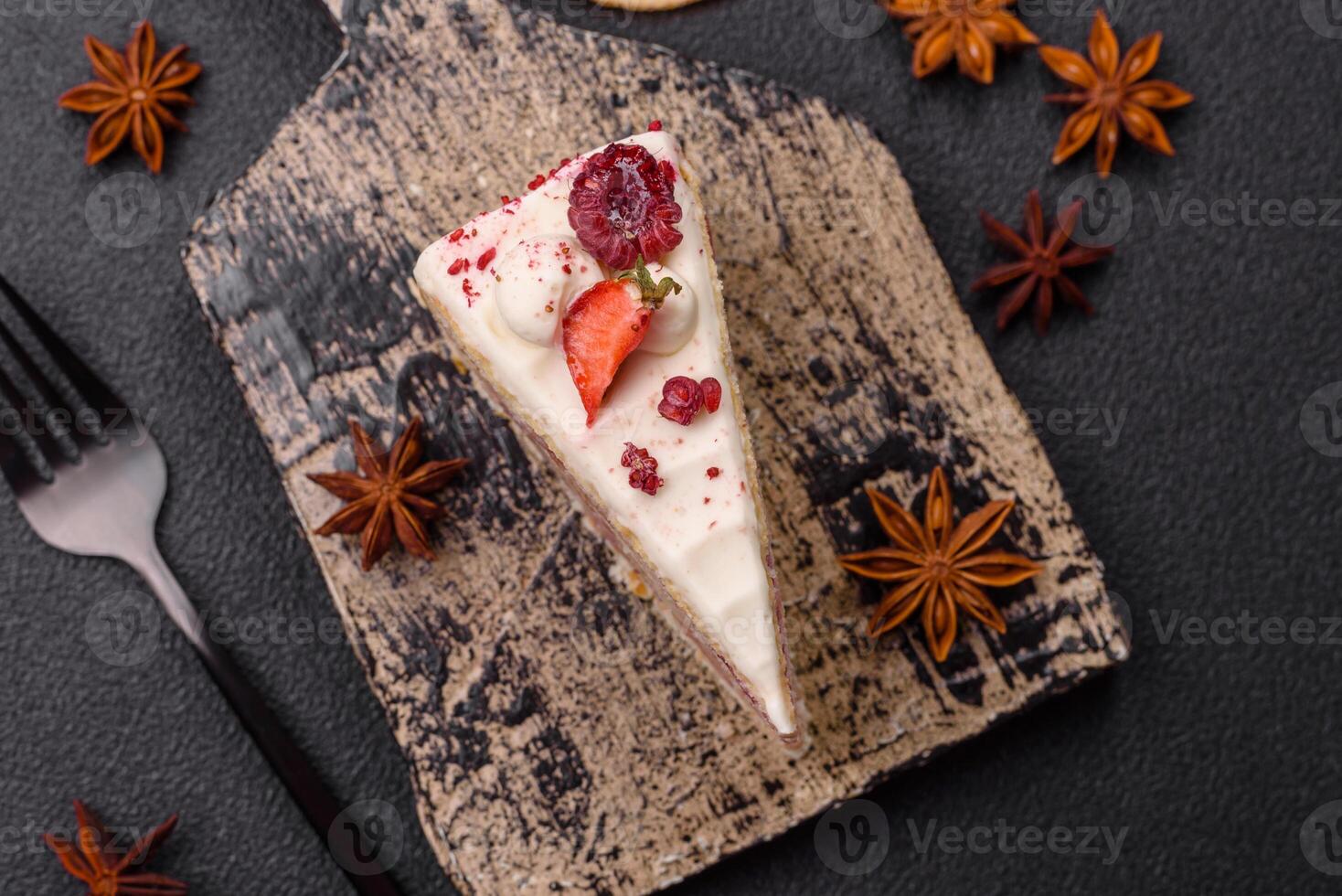 Piece of sweet layer cake with white cream, raspberries and strawberries photo