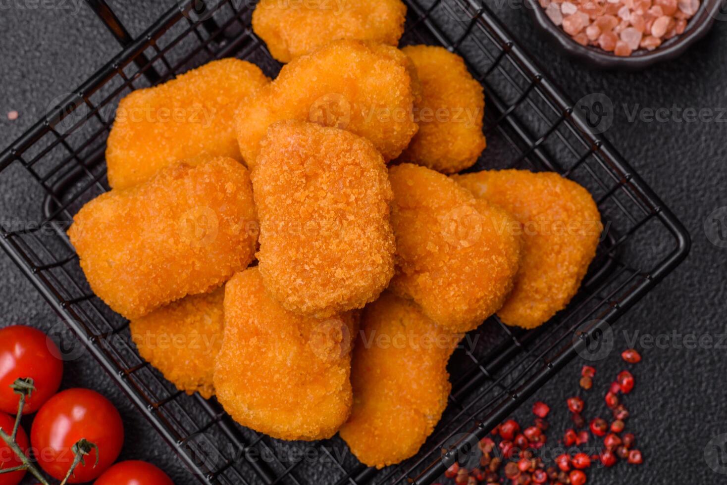 Delicious fresh crispy chicken nuggets on a dark concrete background photo