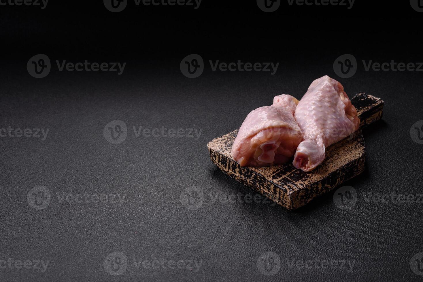 Raw chicken legs with salt, spices, herbs and tomatoes photo