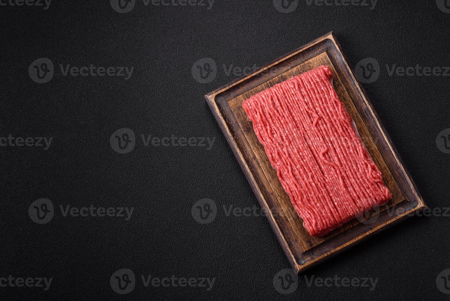 Raw ground beef or pork with salt, spices, herbs and tomatoes photo