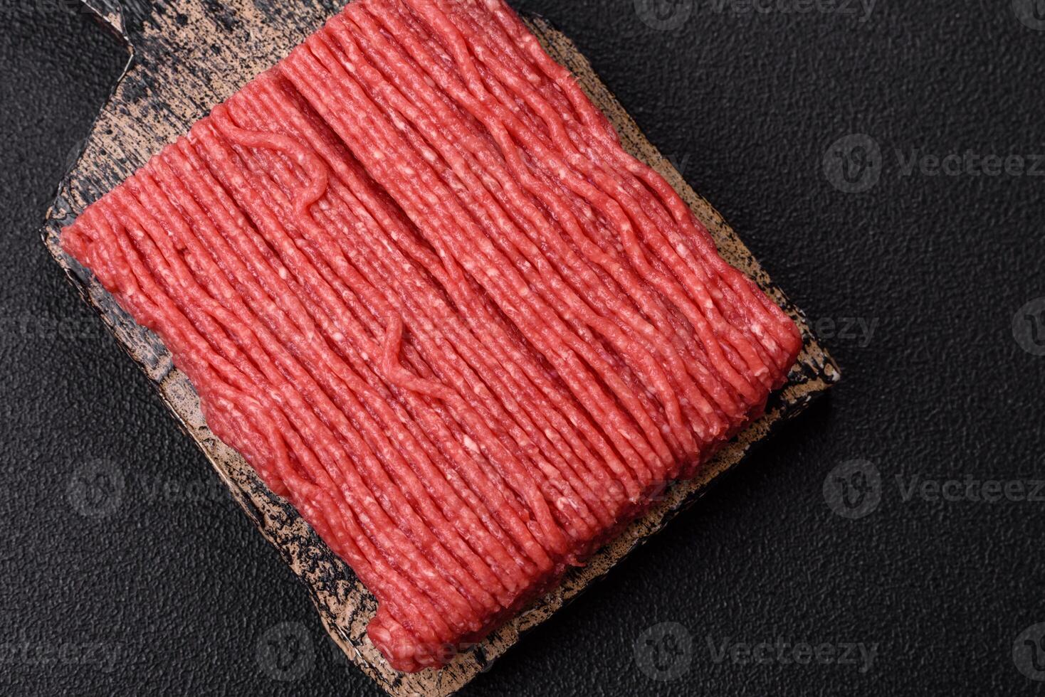 Raw ground beef or pork with salt, spices, herbs and tomatoes photo