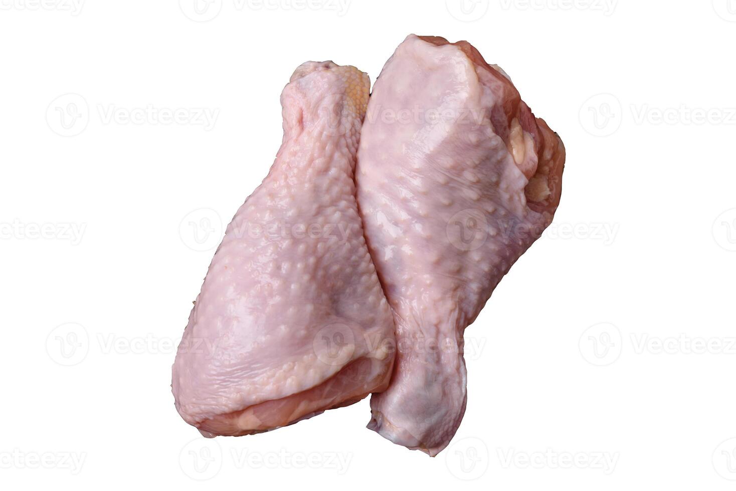 Raw chicken legs with salt, spices, herbs and tomatoes photo