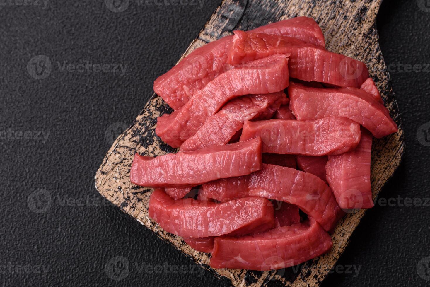Juicy raw beef cut into slices with salt and spices photo