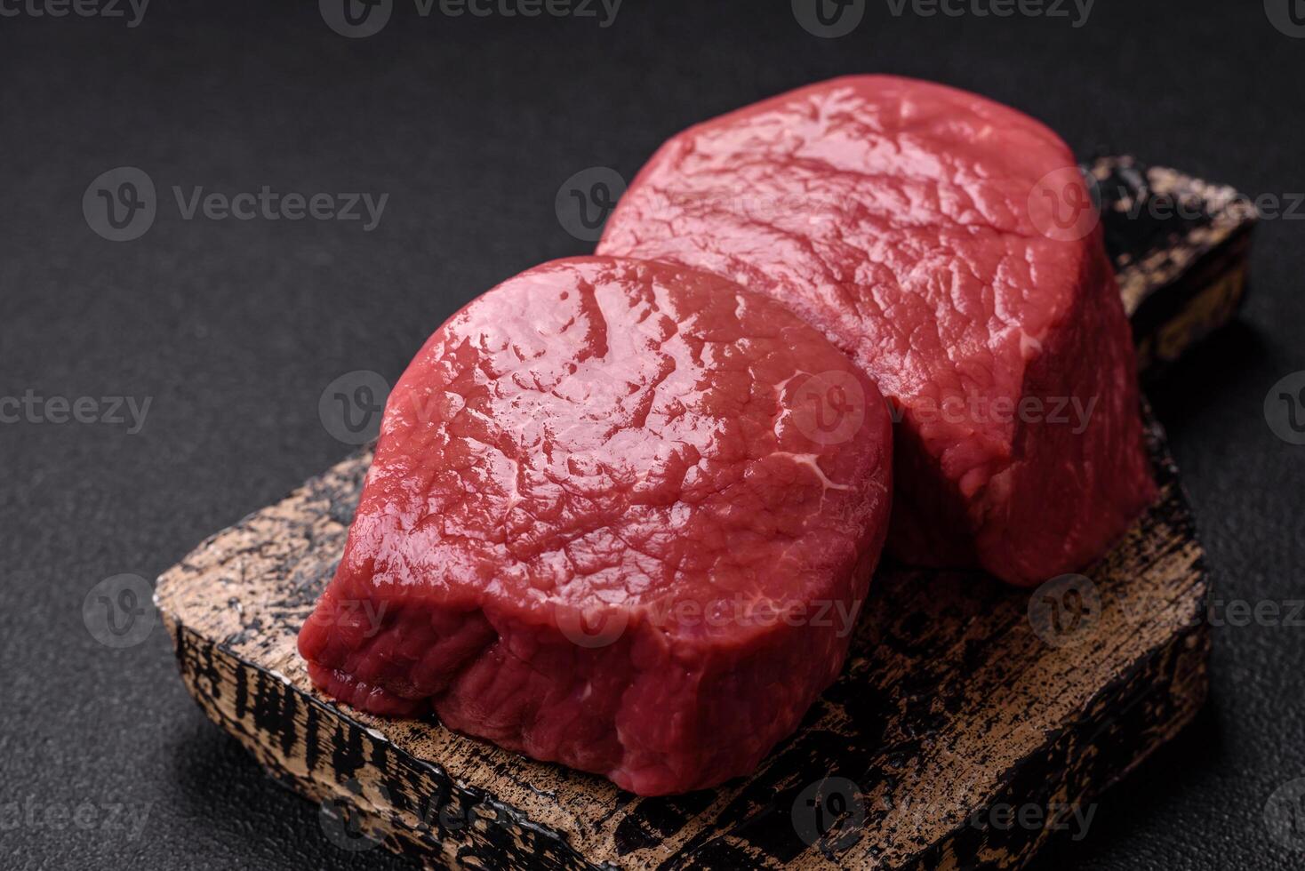 Raw beef eye steak round with salt, spices and herbs photo