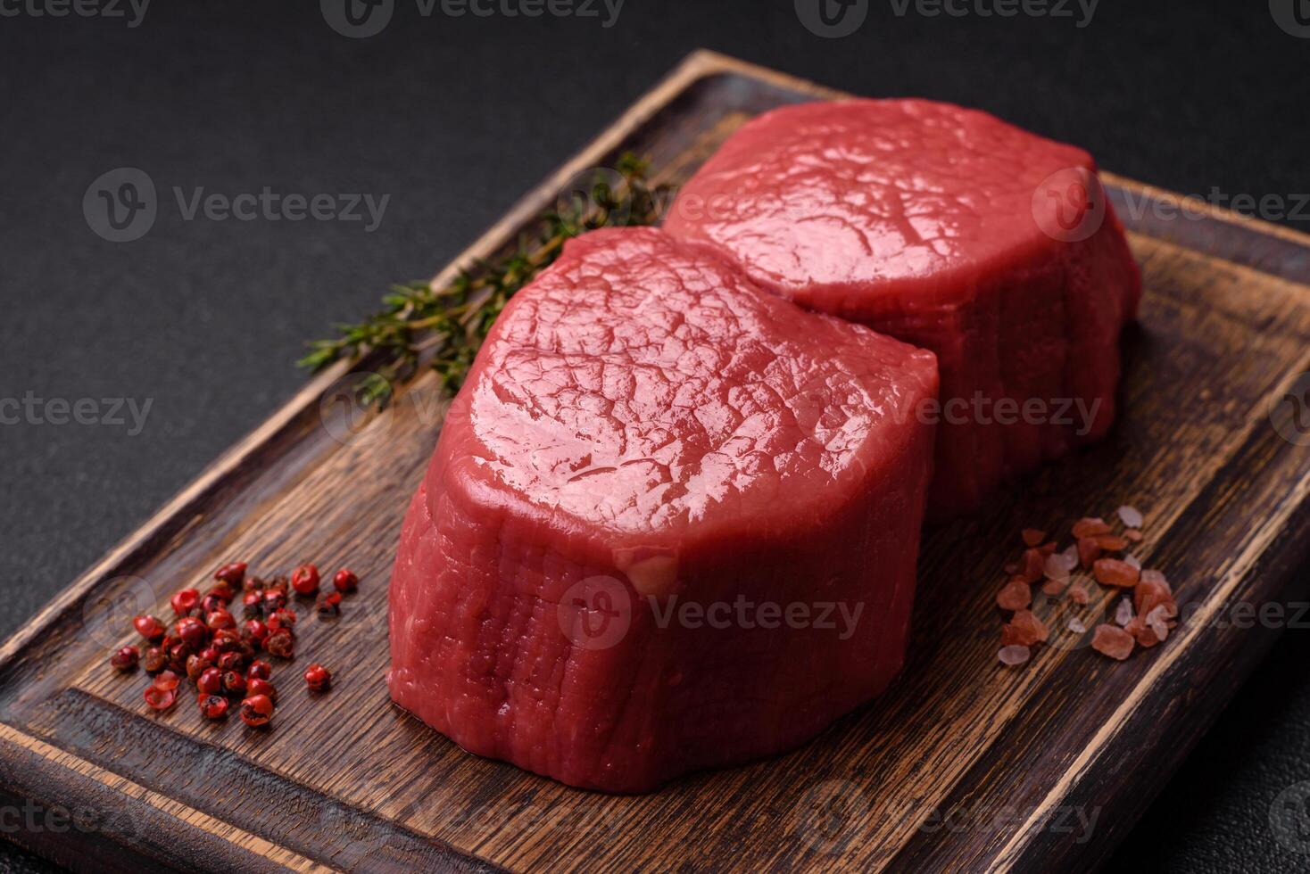 Raw beef eye steak round with salt, spices and herbs photo