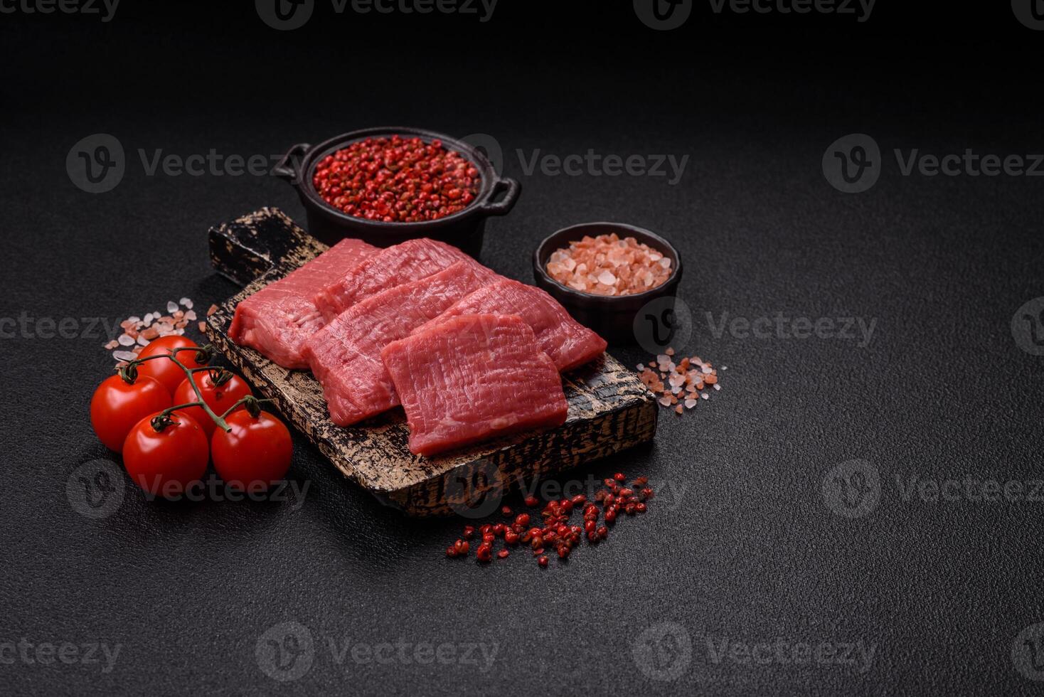 Juicy raw beef cut into slices with salt and spices photo