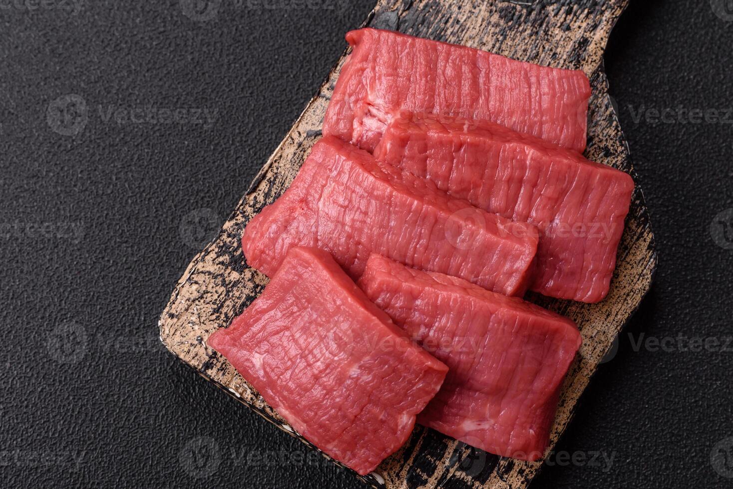 Juicy raw beef cut into slices with salt and spices photo
