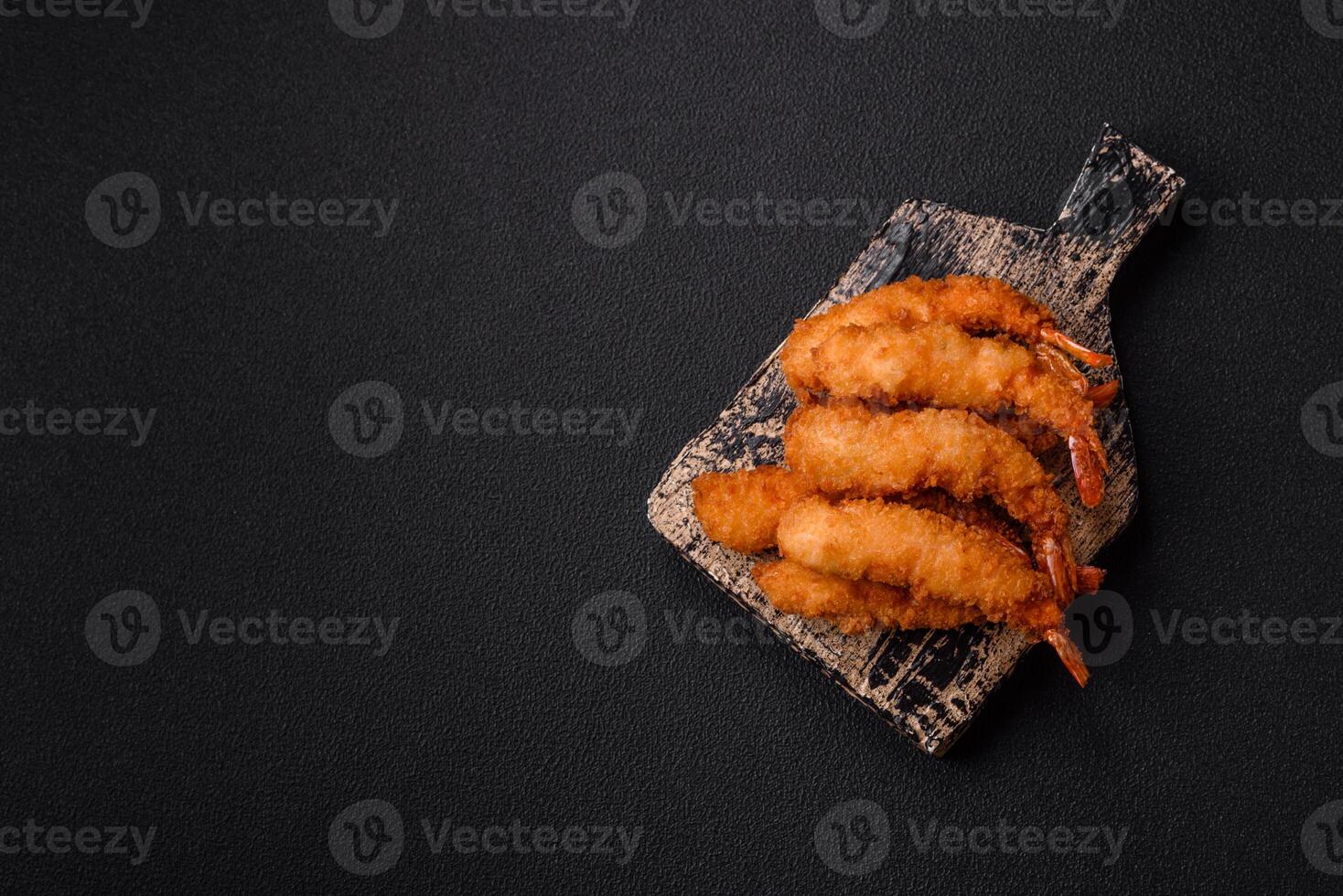 Hot crispy shrimp breaded with salt and spices with white sauce photo