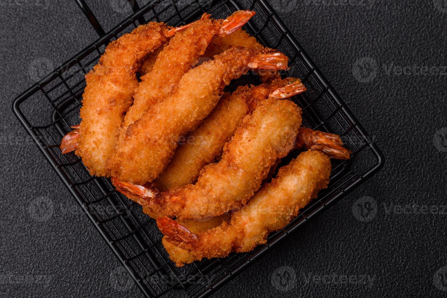 Hot crispy shrimp breaded with salt and spices with white sauce photo